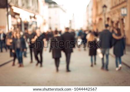 People rush on the street. Blurred crowd of different people are walking in the city. Defocused background of city life. 