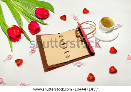 top view of a workspace with a notepad, flowers, a cup of coffee and a beautician for beauty