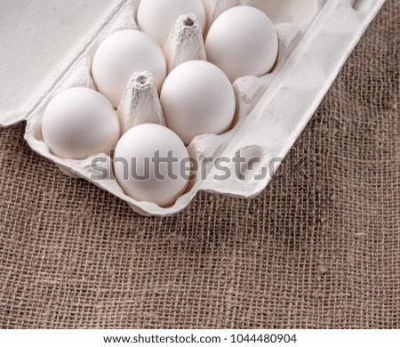 Open packing with white eggs on a fabric background