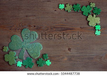 Blackboard with four-leaved clover. St Patricks Day corner border of shamrocks over a rustic wood background. Free space. St. Patrick's Day lucky charms background. 