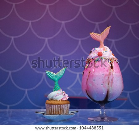 Mermaid cupcake and mermaid rainbow milkshake. With soft focus on the green fish tail in the cupcake. fairy takes and fantasy concept.