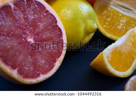 Colored Citrus fruits on a dark blue background. Slices of citrus and peel. Citrus reticulata, paradisi, limon, sinensis. 