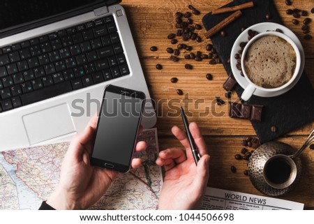 workplace of young freelancer man or woman with coffee, laptop, smartphone in morning on wooden table