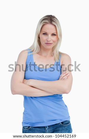 Blonde woman looking at the camera with arms crossed against a white background