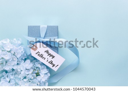 Top view aerial image of decoration Happy Fathers day holiday background concept.Flat lay dad white card with blue flower on modern beautiful  blue paper at home office desk.Free space for design.