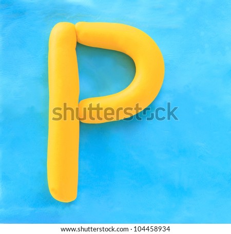 yellow clay alphabet letter with drop shadow on blue clay