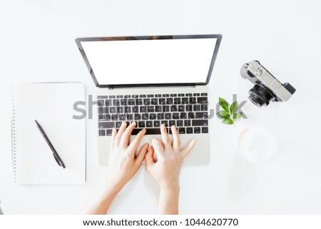 Top view of hand use laptop computer with blank screens on white office desk table.Flat lay