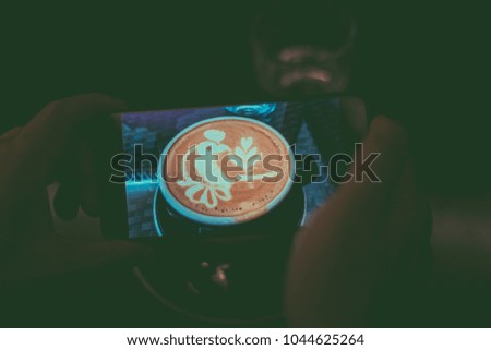 Hand man takes a picture of coffee to the phone