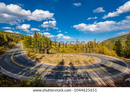 Highway with hairpin turn (switchback) at autumn sunny day in Rocky Mountain National Park. Colorado, USA.  Royalty-Free Stock Photo #1044625651