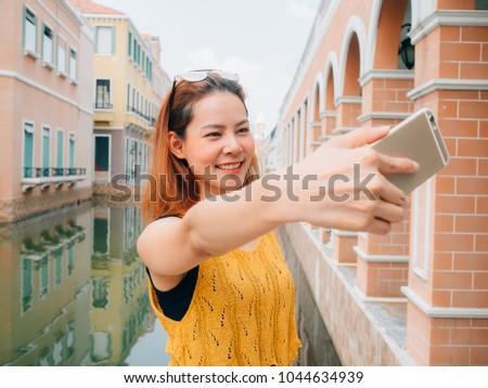 Asian woman tourist is taking selfie photo from the smartphone.