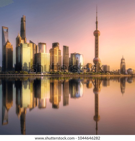 Scenery view of Shanghai skyline and Huangpu river with reflection of sun on buildings and water during sunset, China