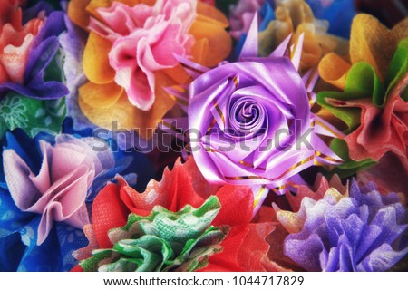 Colorful ribbon flowers and coins folding with mulberry paper for giving alms to make merit in Thai's religious traditional. It is a beautiful picture. Use for colorful background.