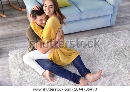 Cute young lovely couple hugging at home