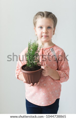 Cute child holding a potted plant