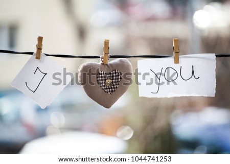 I Love You background. Heart and note with words "I Love You" hanging on a clothesline