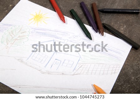 The child draws crayons house