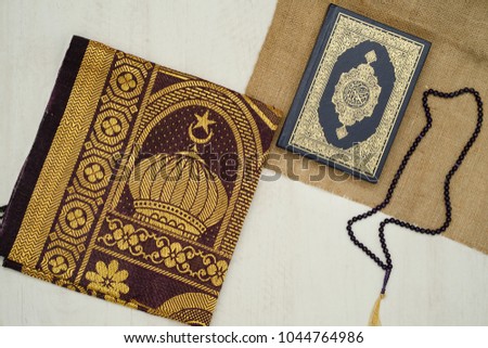 Ramadhan objects. Holy Quran, beautiful beads, prayer rugs, and moslem clothes. Royalty-Free Stock Photo #1044764986