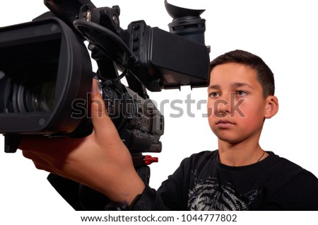 Young boy learning how to filming with professional video camera .Education and technology, studio shot. Excellent clipping path.