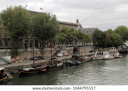 PARIS, FRANCE - 05 SEPTEMBER 2017: Moored boats along Seine River, Paris France against Paris cityscape.