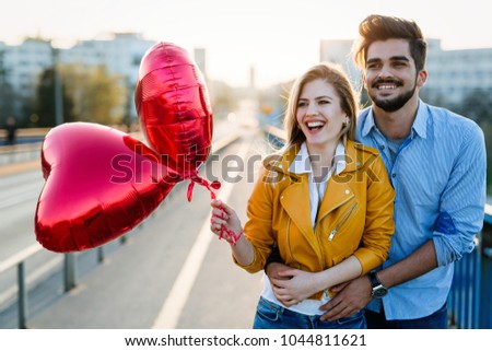 Picture of romantic couple standing outside with baloons