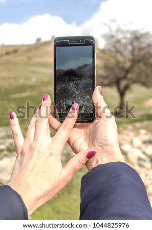 Girl takes pictures of a mountain landscape