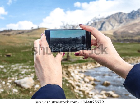 Girl takes pictures of a mountain landscape