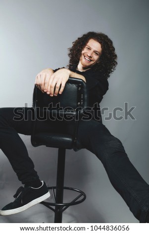 Attractive young man with long ginger curly hair studio portrait