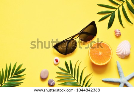 Tropical Background. Palm Trees Branches with starfish and seashell on yellow background. Travel. Copy space Royalty-Free Stock Photo #1044842368