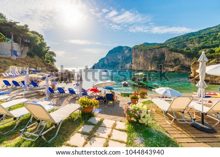 Sunbeds and umbrella on the beach in Corfu Island, Greece. Royalty-Free Stock Photo #1044843940