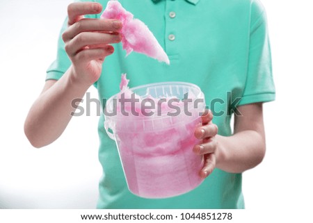 sweet pink cotton candy in the hands of a teenage boy