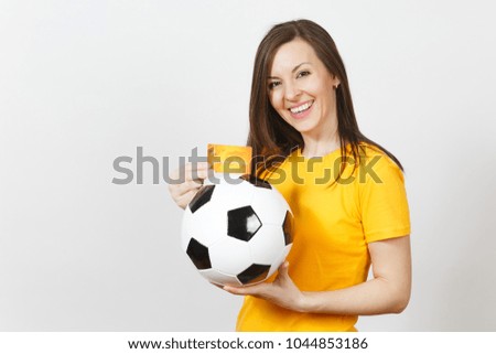 Beautiful European young cheerful woman, football fan or player in yellow uniform holding credit card soccer ball isolated on white background. Sport, play football game, excitement lifestyle concept