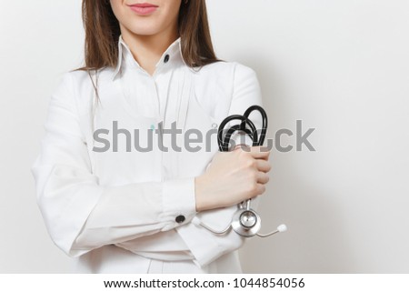 Close up cropped doctor woman with stethoscope isolated on white background. Female doctor in medical gown holds hands folded. Healthcare personnel, medicine concept. Copy space for advertisement