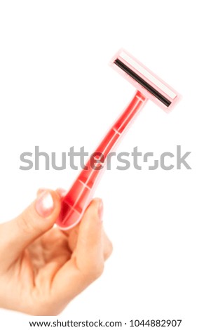 Disposable shaver isolated on abstract blurred white background. Epilation, razor hair removal and skin care concept. Man & woman body depilation treatment. Detailed closeup with soft selective focus
