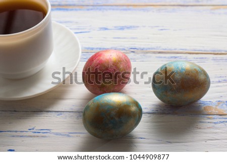 Easter Eggs and Cup of Coffee on the Wooden Table. Easter concept.