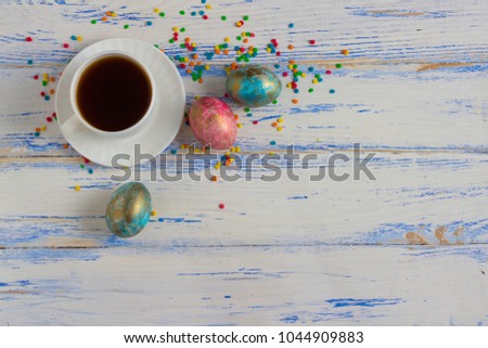 Easter Eggs And A Cup Of Coffee, Multicolored Decoration Sweets On A White Wooden Table. Easter concept.