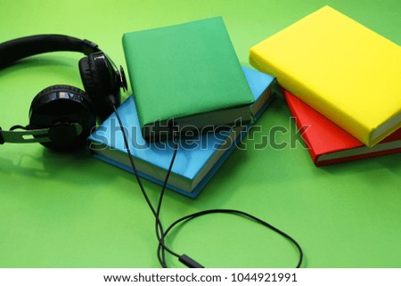 concept of audio books. books in colored covers and headphones on the desktop.