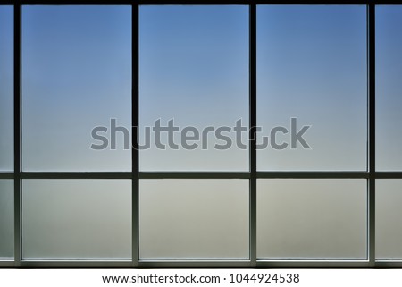 The glass window of building with white aluminum framework, Blue tone as background. Royalty-Free Stock Photo #1044924538
