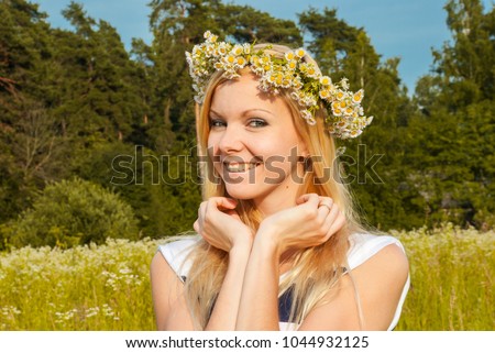Girl on a walk with a spring wreath of flowers on her head in the Park.