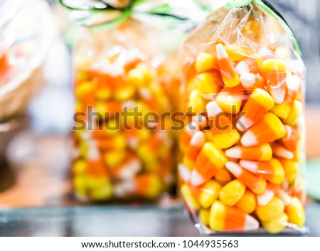 Closeup of colorful orange yellow candy corn on display packaged in plastic bag in candy store shop for Halloween holiday season trick or treat