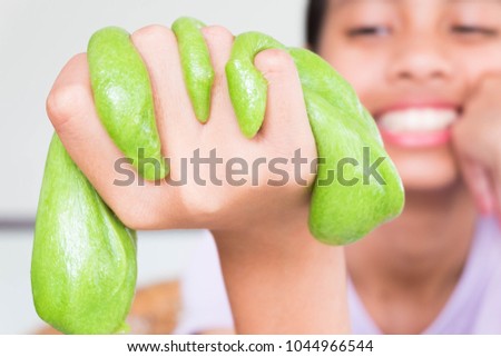 Hand Holding Homemade Toy Called Slime, Kids having fun and being creative by science experiment. Royalty-Free Stock Photo #1044966544