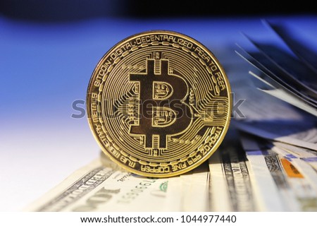 Bitcoin is a gold coin on dollar bills. Financial concept