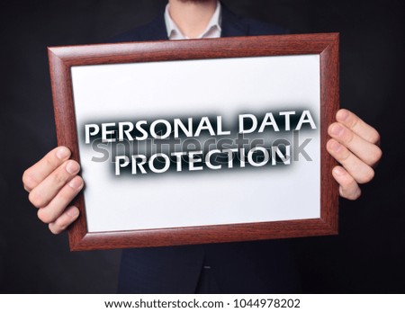 In the hands of a businessman a frame with the inscription:PERSONAL DATA PROTECTION