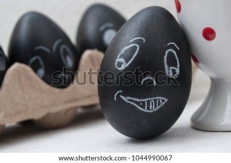 closeup of black funny easter eggs with expressive face drawn in chalk