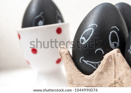 closeup of black funny easter eggs with expressive face drawn in chalk