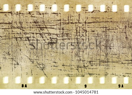 Vintage scratched film strip frame in sepia tones with copy space.