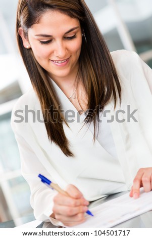Business woman signing a contract  and smiling