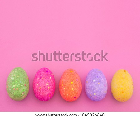 Decorated colorful Easter eggs on pink paper background with space for text. Trendy minimal pop art style and colors.