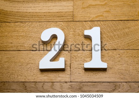 Figure twenty - one on a wooden, parquet floor as a background.