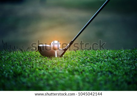 Blurred golf club and golf ball close up in grass field with sunset. Golf ball close up in golf coures at Thailand Royalty-Free Stock Photo #1045042144