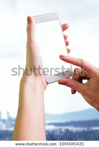 Digital composite of Hand holding phone with landscape white washed